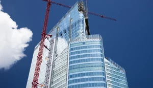 Upward view of a crane building a skyscraper.