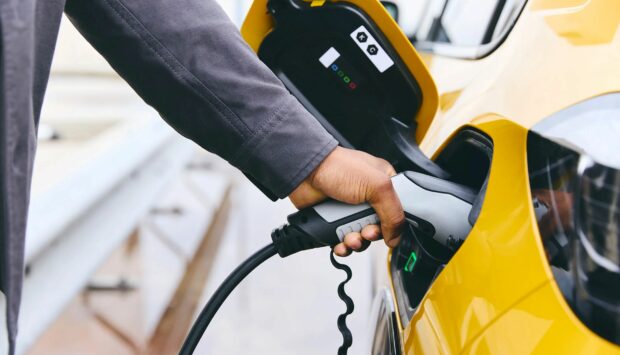 Person plugging their electric vehicle into a charger