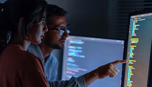 Two people working together at a monitor